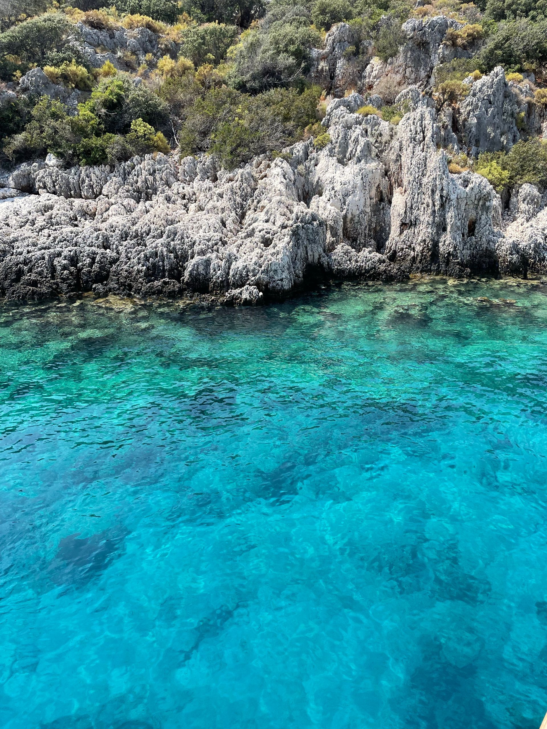 Aerial view of a turquoise cove and rocky cliffs